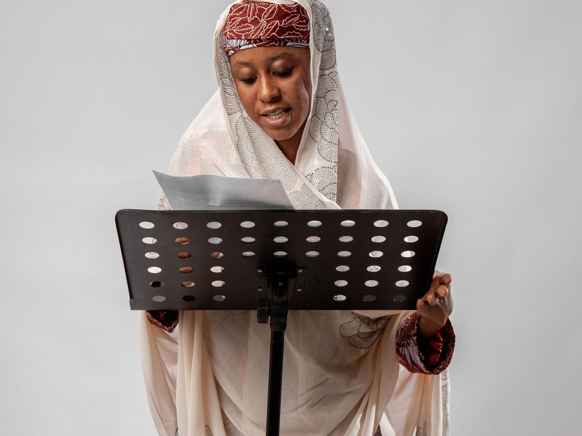 A singer holding sheet music, preparing to register